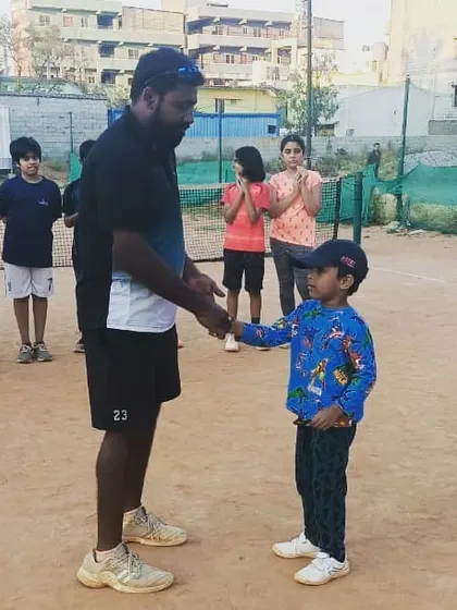 Even our youngest players are contenders for 'Player of the Week'. Here, I'm congratulating a young champ for his focus and positive attitude during our kids' tennis lessons.