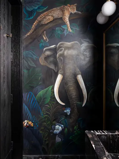 Welcome to the jungle. This powder room in our Bengaluru project features a breathtaking, hand-painted mural of jungle animals, creating a completely immersive and unexpected experience.