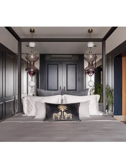A master suite should be a sanctuary. For this high-rise apartment, we created a moody and luxurious retreat with a custom four-poster bed, deep blue paneling, and exquisite blown-glass pendant lights. The design balances opulence with personal comfort, creating a space that feels like a private escape from the city below.