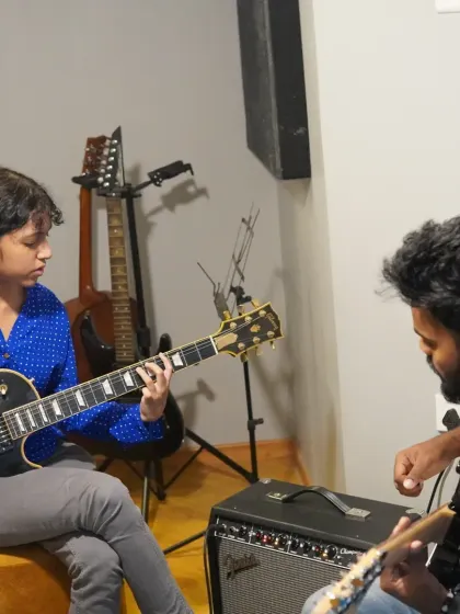 A guitar student receiving one-on-one instruction from her teacher. These personalized sessions are key to rapid progress.