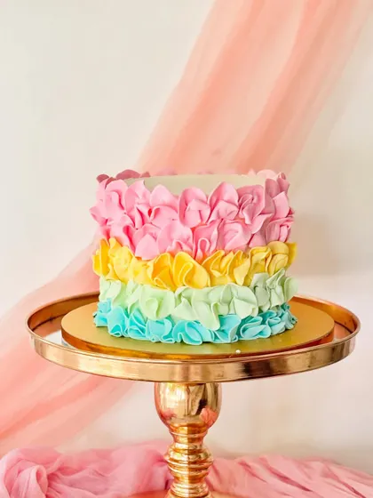 A cake with beautiful, soft buttercream ruffles in a rainbow of pastel colors. This technique creates a delicate, fabric-like texture.