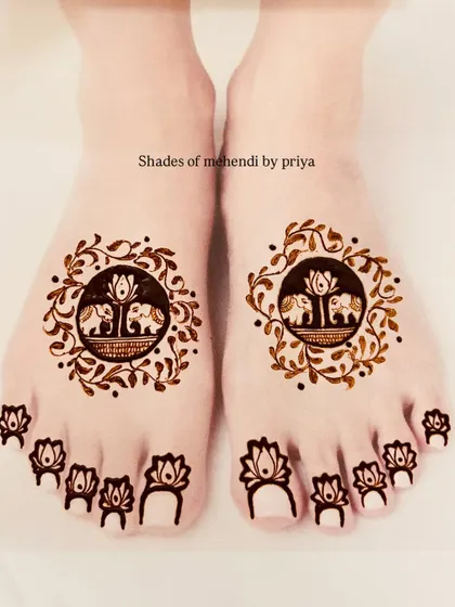 Another cute and minimal foot design. This one has a circular frame with two elephants, surrounded by a leafy vine, and simple lotus designs on the toes.
