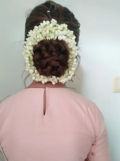 A classic and elegant bridal bun, beautifully encircled with fresh jasmine flowers (gajra). This is a timeless hairstyle for any traditional occasion.