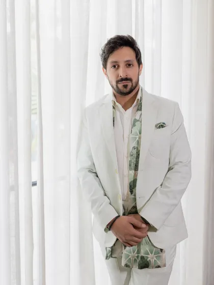 A dapper portrait of the groom in his stylish white suit, looking sharp and ready for the engagement party.