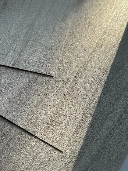 The sunlight catches the subtle texture of this elegant grey wallpaper, showcasing how even a simple design can embody grace and simplify your surroundings.