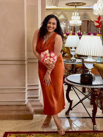 A beautiful photo of me with a bouquet of roses from our anniversary celebration. It's a romantic and happy image that shares a personal, celebratory moment.