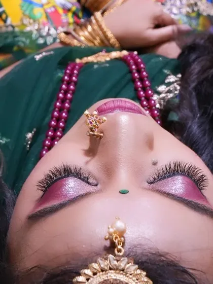 An artistic close-up shot focusing on the eye makeup and jewelry, with the Langa Davani providing a rich, colorful base.