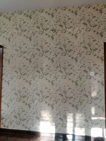 A delicate, scattered floral pattern in a neutral color scheme. This wallpaper adds subtle texture and interest to the wall without being overwhelming, making it a great choice for a calm and restful bedroom.