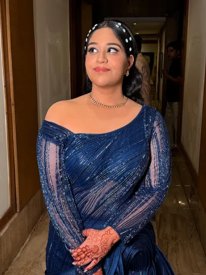 A beautiful party look featuring a stylish side-parted hairstyle with pearl accessories and soft, glowing makeup.