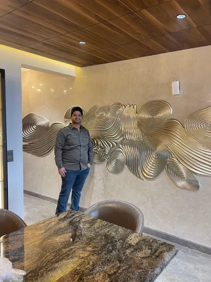 The entry passage sets a luxurious tone with a stunning silver leafing mural against a textured wall, complemented by a beautiful marble dining table.