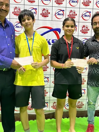 Two of my female players proudly displaying their medals and prize money after a successful tournament performance.