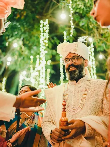 A candid shot of the groom during the wedding festivities, sharing a moment with his family. His happy expression shows the joy of being surrounded by loved ones.
