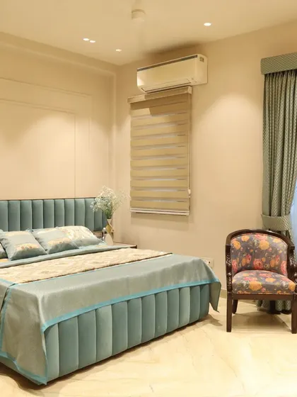 A view of the bed and window area, showing the layered curtains and the serene color palette designed for a peaceful retreat.