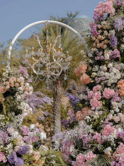 A detail of the floral arrangements on the mandap, featuring a mix of pastel roses and hydrangeas with a crystal chandelier. This juxtaposition of soft florals and elegant crystal is a signature of my style.