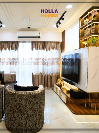 A view of the Parisian-themed living room, highlighting the custom TV unit with marble and wood finishes, and display shelves with integrated lighting.