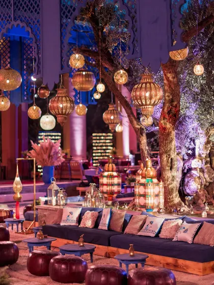 The Sangeet lounge at dusk, with hundreds of lanterns beginning to glow, creating a magical, enchanting atmosphere.