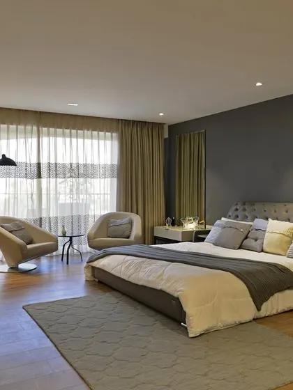 For a client who loves the feel of hotel suites, I designed this master bedroom for Mahindra Lifespaces. The sprawling 4000 sq. ft. space includes an inviting sitting area, blending the grandeur of a five-star hotel with the warmth of home.