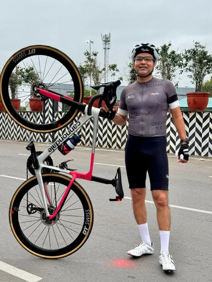 A member proudly lifting his Cannondale bike, a common celebration after a great ride.