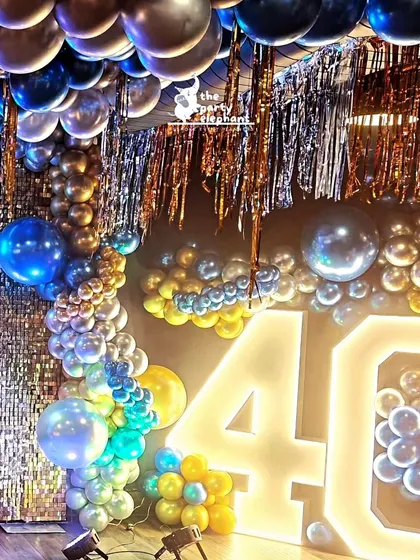 The combination of the glowing marquee '40' and the shimmering silver sequin wall created a dynamic and glamorous photo opportunity for the birthday guests.