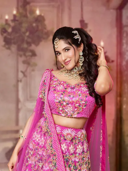 This stunning reception look features a heavy Kundan and pearl choker set against a vibrant pink lehenga. It is a glamorous choice that is sure to make heads turn.
