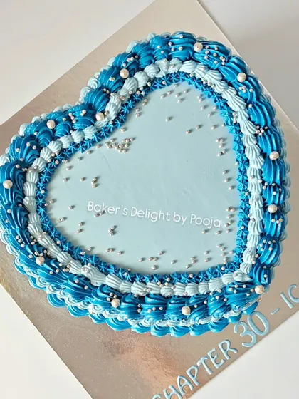A top-down view of the blue and silver heart cake, showing the layered piping work that gives it its timeless, elegant appeal.