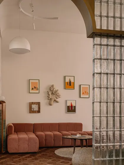 Another perspective of the daughter's bedroom, showing the glass block wall and the curated collection of art that gives the space its unique personality.