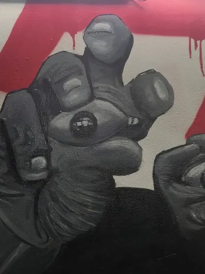 A detail shot of hands holding eyes, a surreal element from the "STATES OF MIND" mural. This part of the piece explores themes of perception and perspective.