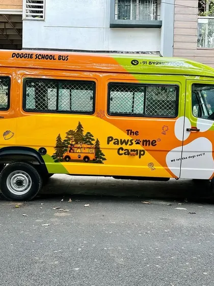 The Pawsome Camp bus, seen from the side, showcasing our fun branding. We let the dogs out, and we bring them back happy.
