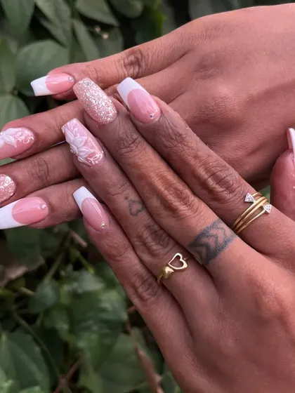 A timeless bridal look combining a classic French manicure with delicate 3D floral sculptures and glitter accents. This set of acrylic extensions shows how we can blend classic elegance with personalized art for your special day.