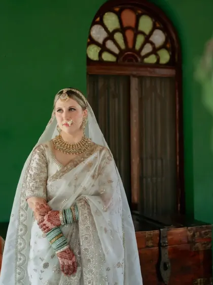 The bride's henna-stained hands are gracefully clasped, showing the deep, even color of the design.
