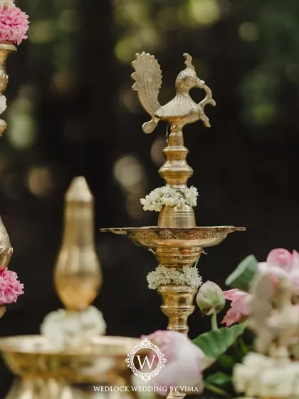 Details from a minimal and serene wedding setup. The decor features serene lotuses, traditional brass lamps, and other meaningful elements that reflect the couple's vision.