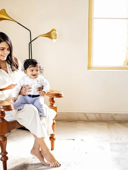 A mother and her baby sharing a happy moment in a classic wooden chair. I love finding unique spots in your home that make for beautiful portraits.