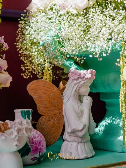 A close-up of a fairy-like statue with butterfly wings, a whimsical detail that adds to the magical, fairytale atmosphere of the 'Mint to Be' theme.