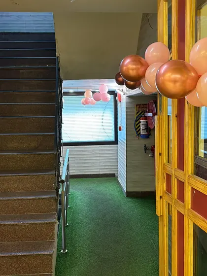 The entrance to the anniversary party venue, decorated with pastel and chrome balloon bunches to welcome the guests.
