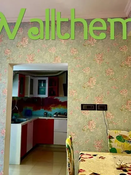 A dining area with a green and pink floral wallpaper, creating a cheerful and inviting atmosphere.