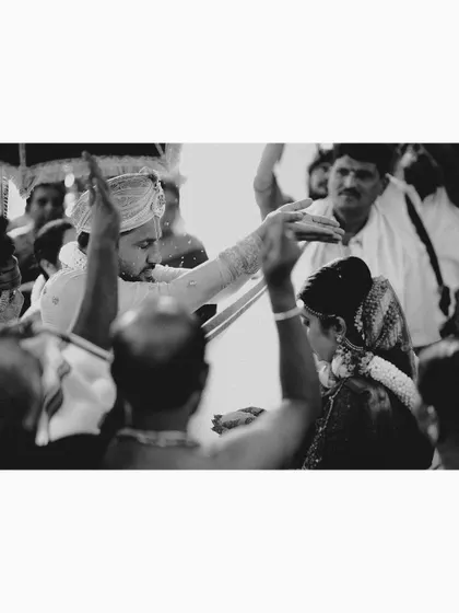 A powerful black and white shot of the couple during a key ritual, surrounded by their family.