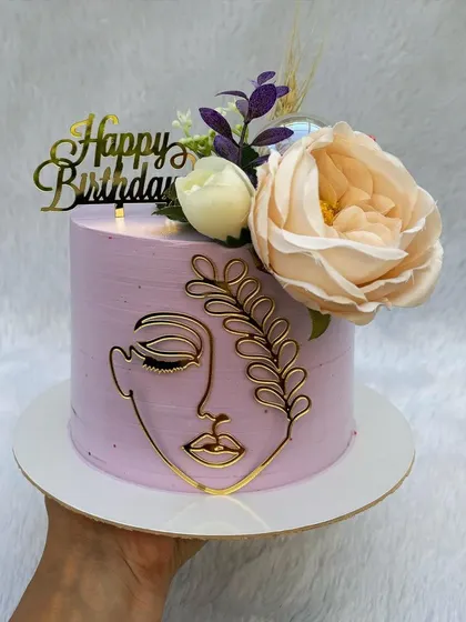 A similar line-art cake, this time on a lavender base. The combination of the abstract gold face, flowers, and pastel color is very chic.