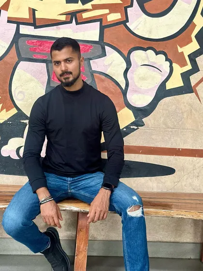 A confident and cool pose in a simple black long-sleeve and ripped jeans.