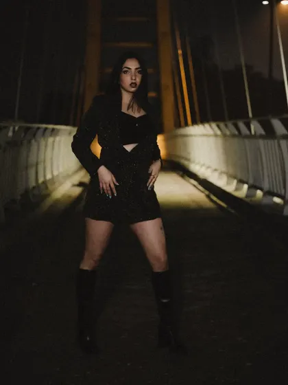 A powerful stance on the bridge, with the city lights in the background creating a beautiful bokeh effect.