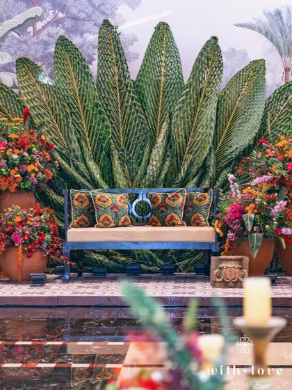 The full setup for a Pellikuthuru ceremony, with the woven leaf backdrop and abundant floral arrangements creating a festive and traditional atmosphere.