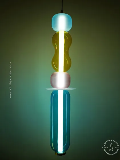 Add a playful pop of color with these kinetic sculpture pendants. Featuring stacked segments of hand-blown glass in teal, amber, and blush, these lights are a fun and artistic addition to any creative space.