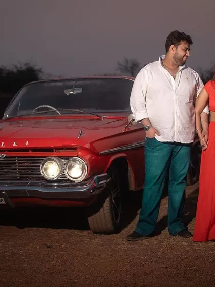 A classic pose with a vintage red car, this pre-wedding photo has a cool, retro vibe that stands out.