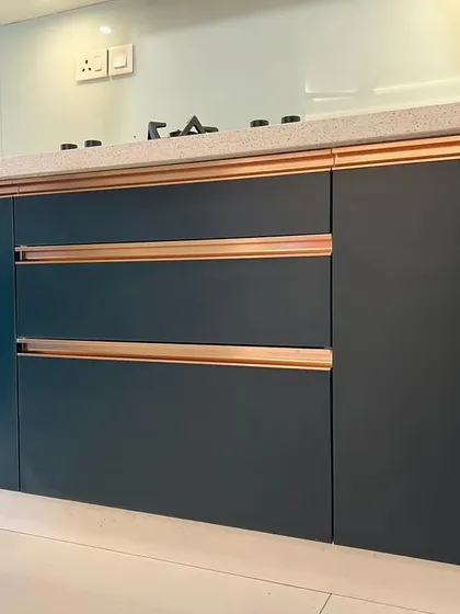A close-up of the navy blue cabinets with custom rose gold profile handles. This detail shot emphasizes the quality and unique hardware we use in our projects.