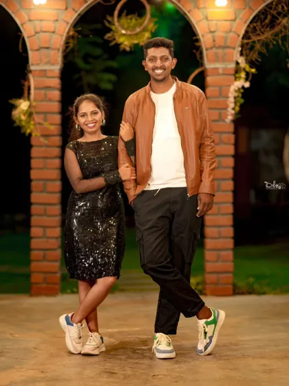 A classic couple's portrait in a stylish night-time setting. The casual yet chic outfits work perfectly with the modern backdrop.