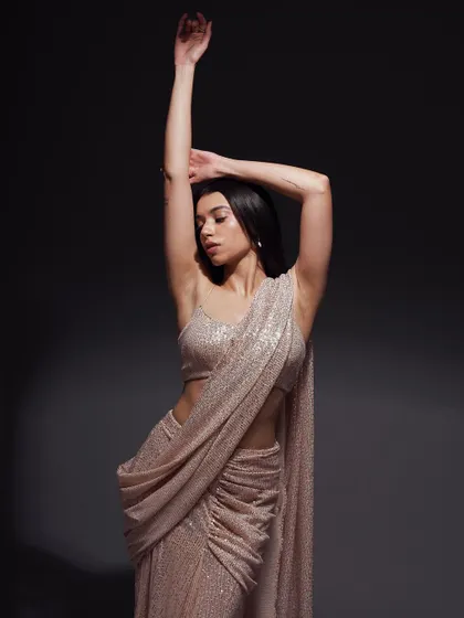 A graceful, expressive pose with arms raised. This shot captures a sense of freedom and movement, adding a dynamic quality to the elegant saree.