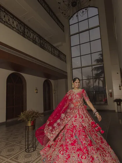A joyful, twirling portrait of the bride in the hotel lobby, her vibrant lehenga in full, beautiful motion.