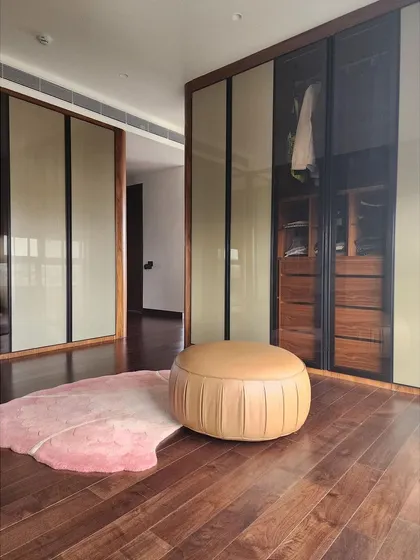 We combined two bedrooms to create this spacious master suite, featuring a large walk-in wardrobe with smoked glass and wood finishes. The design provides ample storage while maintaining a sleek, uncluttered aesthetic, blending functionality with high-end residential design.