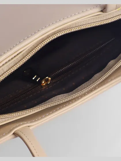 A close-up of the interior zipper and lining of a beige handbag. Detail shots like this build trust and justify a premium price.