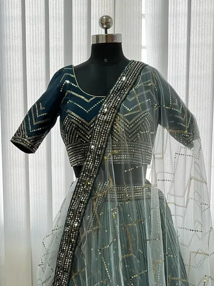 Our modern teal blue lehenga, featuring striking geometric patterns in silver and gold sequin work. This outfit is perfect for a cocktail party or a contemporary wedding event.