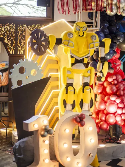 A massive Bumblebee prop from a Transformers-themed 10th birthday. This impressive, detailed character stands next to '10' marquee lights, creating a major wow-factor.